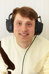Image showing Cheerful guy with big ear-phones on a head