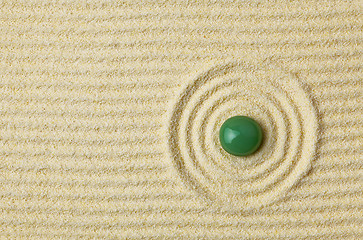 Image showing Green stone on surface of yellow sand