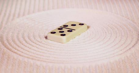 Image showing Dominoes on sand in rock garden