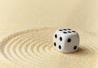 Image showing Playing white dice on yellow sand - art miniature