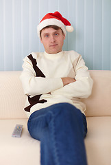 Image showing People in a Christmas hat sits on a sofa