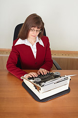 Image showing Woman prints on an ancient typewriter