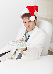 Image showing Man in Christmas hat gives us money