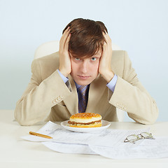 Image showing Person at office on workplace with a hamburger