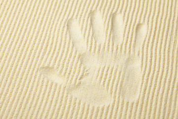 Image showing Trace from palm on surface of yellow sand