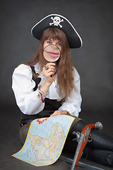 Image showing Woman - captain of sea pirates with map and magnifier in hands