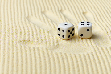 Image showing Dices on sand surface and palm print - art composition