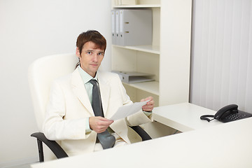 Image showing Young businessman sits in the study