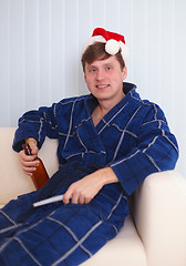 Image showing Person in red santa s cap sits on sofa