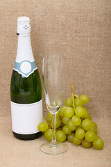 Image showing Still-life from bottle of sparkling wine, glass and grapes clust