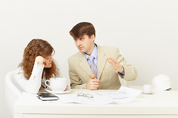 Image showing Businessman explains to missing tired girl drinking coffee