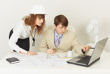 Image showing Two young engineers work over project on laptop