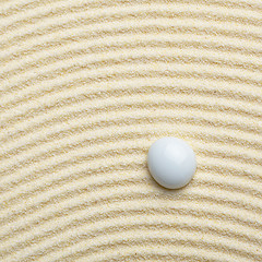 Image showing Stone on surface of yellow sand - square composition