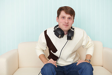 Image showing Man with head-phones on sofa