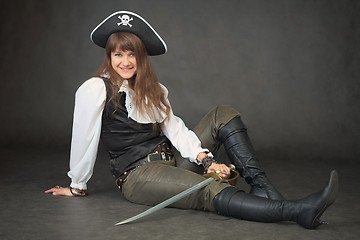 Image showing Sexy woman - pirate sits on black background