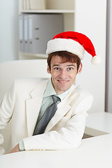 Image showing Happy man in Christmas cap at office