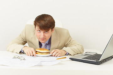 Image showing Young businessman is going to have dinner hamburger at office