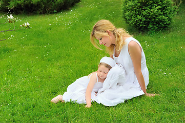 Image showing Young mother and daughter resting in meadow