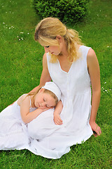 Image showing Young mother and daughter resting in meadow
