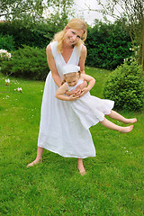 Image showing Young mother and daughter playing in meadow