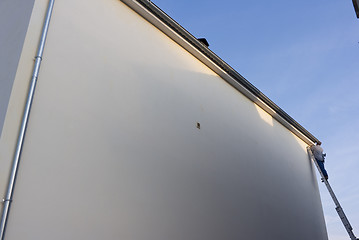 Image showing Man on long ladder