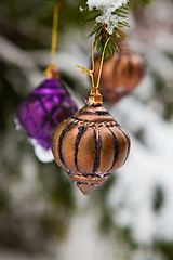 Image showing Christmas baubles on a snowy pine