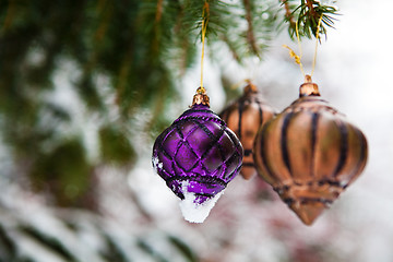 Image showing Christmas baubles on a snowy pine