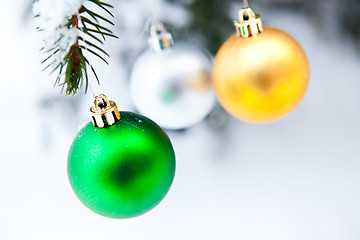 Image showing Christmas baubles on a snowy pine