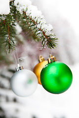 Image showing Christmas baubles on a snowy pine