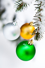 Image showing Christmas baubles on a snowy pine