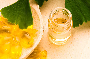 Image showing ginko biloba essential oil with fresh leaves - beauty treatment