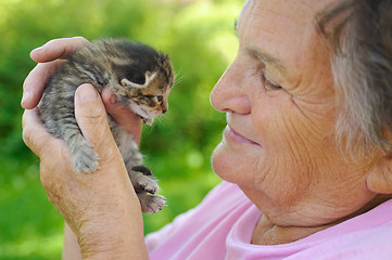 Image showing Senior woman holding little kitten