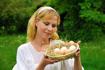 Image showing Happy young woman holding fresh eggs