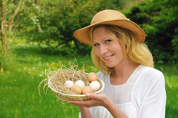 Image showing Happy young woman holding fresh eggs