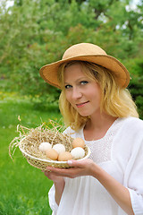 Image showing Happy young woman holding fresh eggs