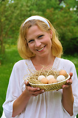 Image showing Happy young woman holding fresh eggs