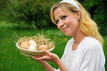 Image showing Happy young woman holding fresh eggs