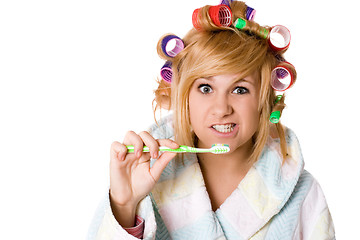 Image showing funny housewife with curlers and toothbrush 