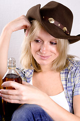 Image showing  woman cowboy with bottle of whiskey