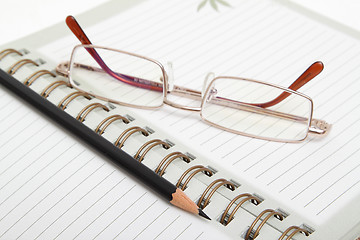 Image showing A diary, pencil and glasses
