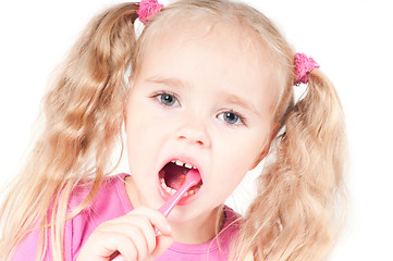 Image showing Little cute girl in studio brushing teeth