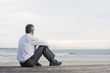 Image showing Pensive businessman sitting at the sea