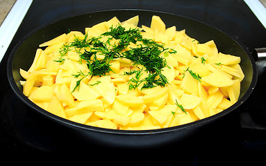 Image showing Sliced raw potatoes on frying pan