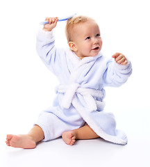 Image showing Cute child in bathrobe with comb