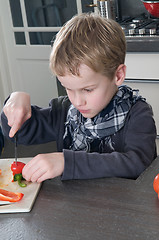 Image showing Boy cutting pepper