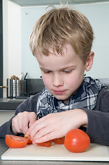 Image showing Boy cutting tomato