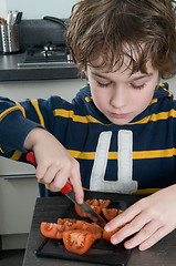 Image showing Boy cutting tomato