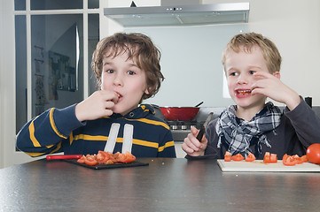 Image showing Boys tasting tomato