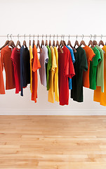 Image showing Variety of multicolored clothes on a rod