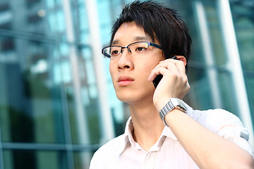 Image showing casual asian businessman talking on his cell phone 